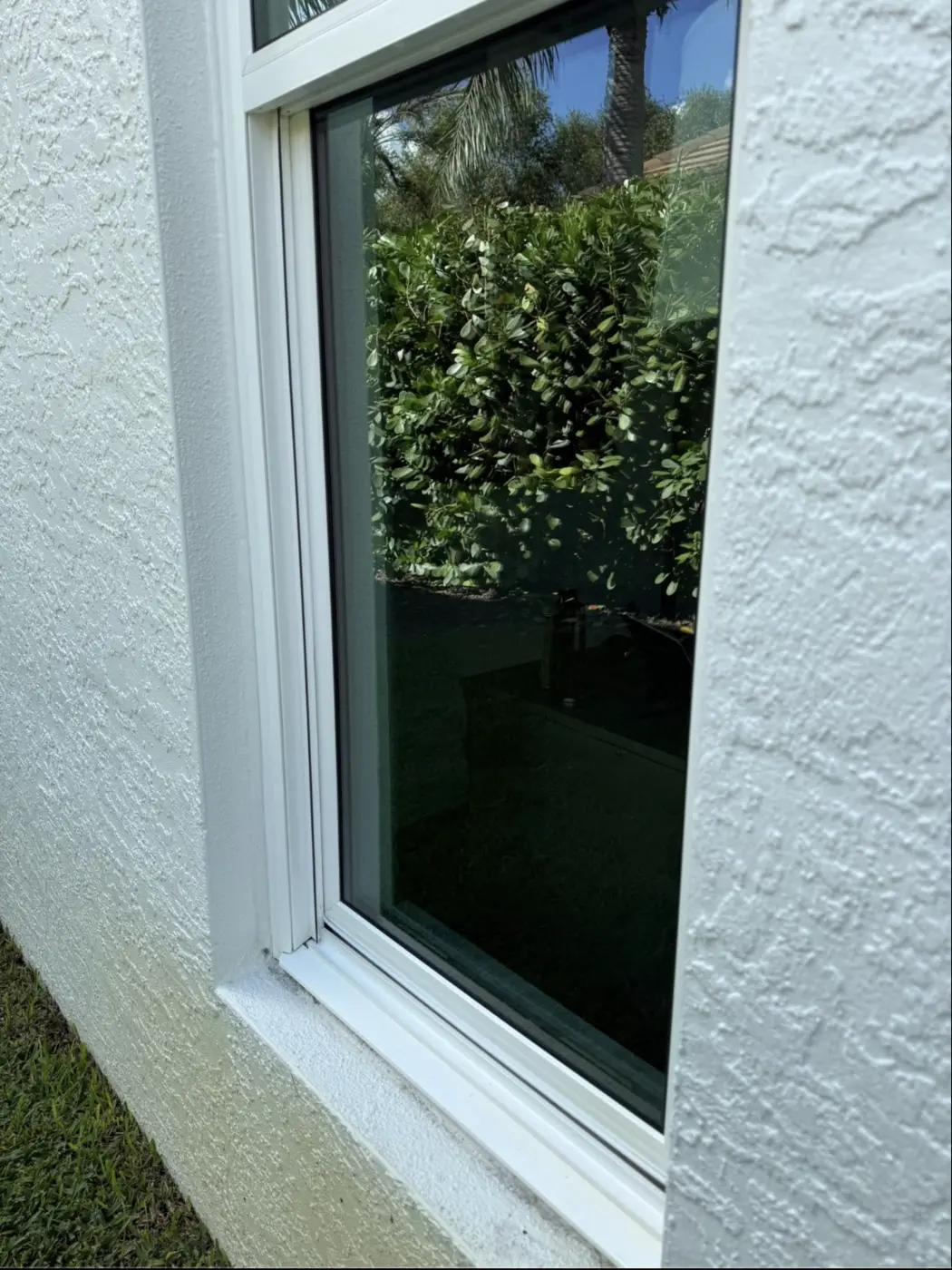 The same window with clear glass and a clean rail after cleaning