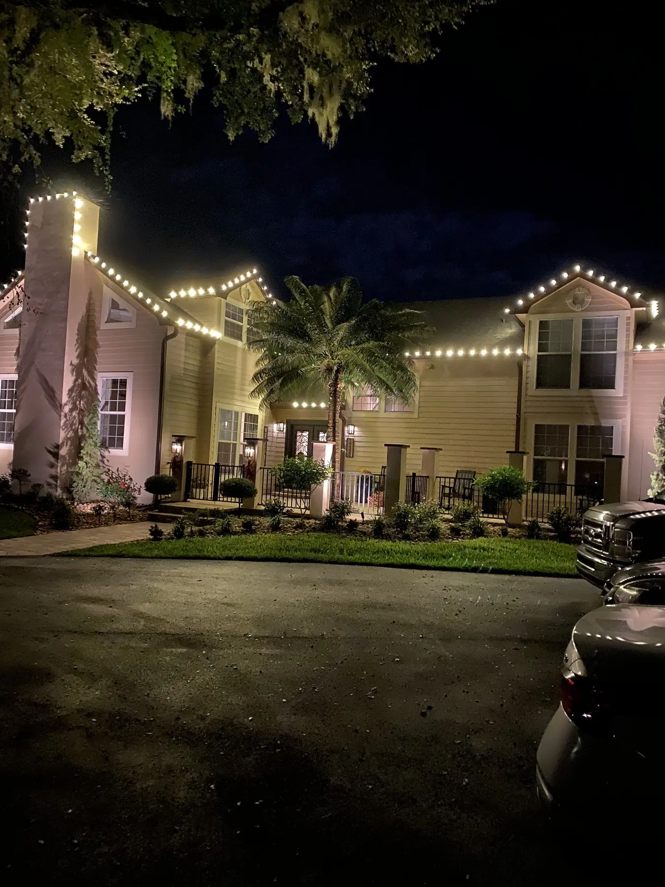 Two-story home with rooflines traced in warm white light